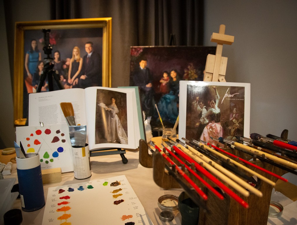 Brushes, palette and portraits in progress at the studio